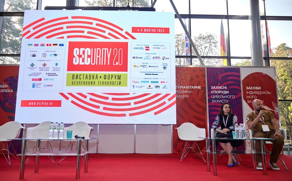 представники АСУ на сцені виставки у сфері безпеки SECURITY 2.0, на фоні великого банеру виставки