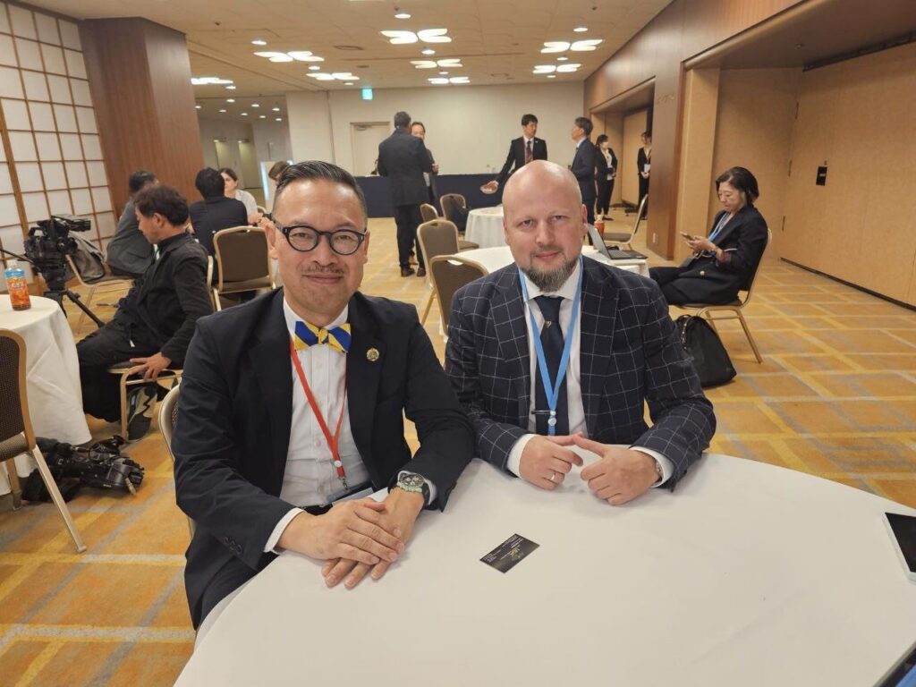 Голова правління АСУ Тимур Пістрюга з японським колегою сидять за столом на конференції